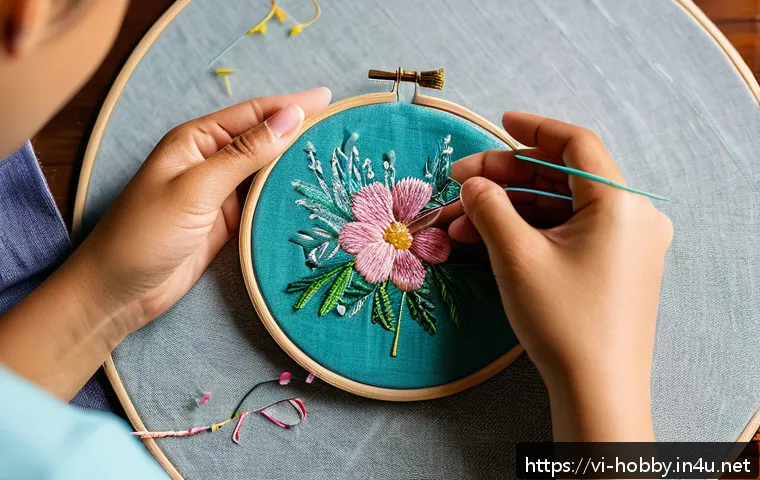 자수 작업 방법 - A detailed close-up of a beginner embroiderer’s hands holding an embroidery hoop with a light cotton...